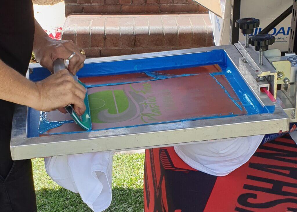 person using squeegee for screen printing