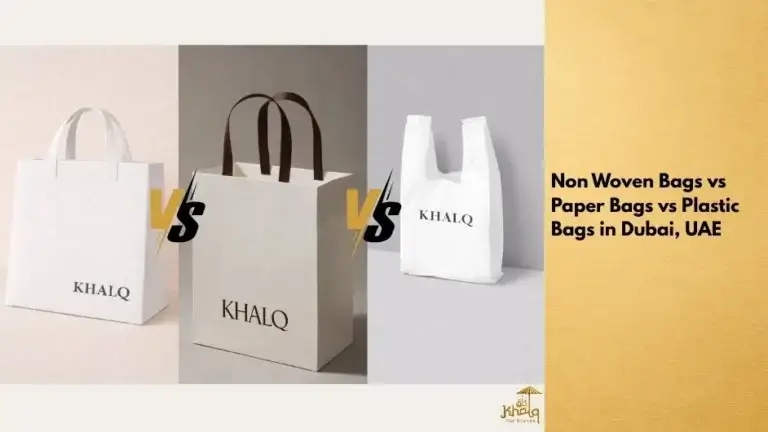 A side-by-side comparison image showing three shopping bags placed on a neutral background. On the left is a white non woven bag with soft handles and the brand name “KHALQ” printed on the front. In the center is a structured paper bag with brown handles and the same brand logo, standing upright. On the right is a thin white plastic bag with loop handles, also branded “KHALQ”. Bold “VS” text appears between each bag, visually comparing non woven bags, paper bags, and plastic bags used by businesses in Dubai.